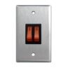 Double light switch with orange toggle switches on a brushed metal plate.