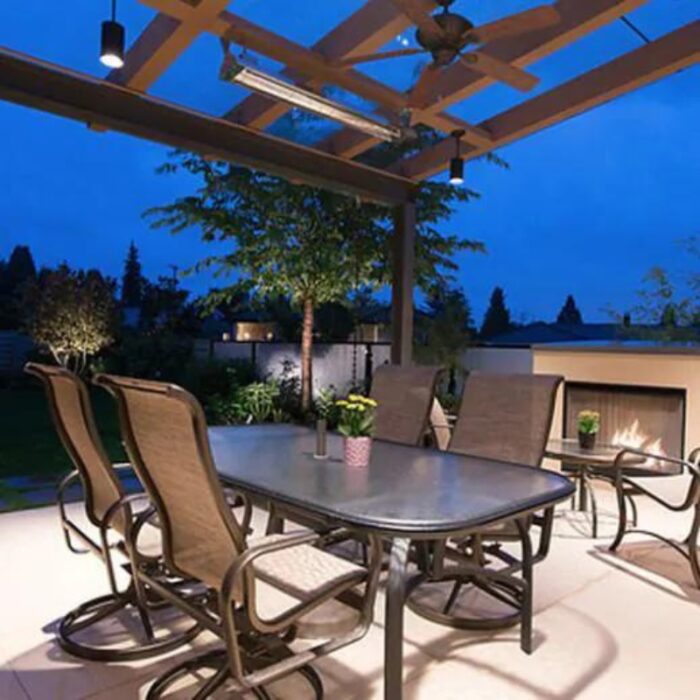 Outdoor patio with a dining table and chairs, illuminated by ambient lighting and featuring a cozy fireplace, set in a serene garden environment at dusk.