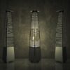 Outdoor patio heaters arranged in a modern setting, providing warmth with glowing flames, against a textured gray wall.