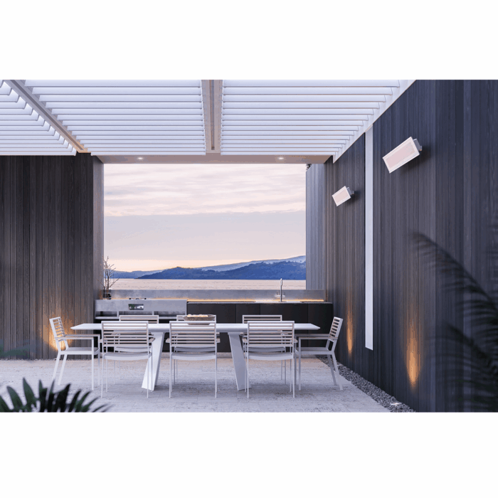 Modern outdoor dining area with sleek furniture and a scenic view of mountains, featuring a stylish pergola and integrated lighting.