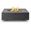 Modern square outdoor fire pit with flames and decorative stones on a gray surface.