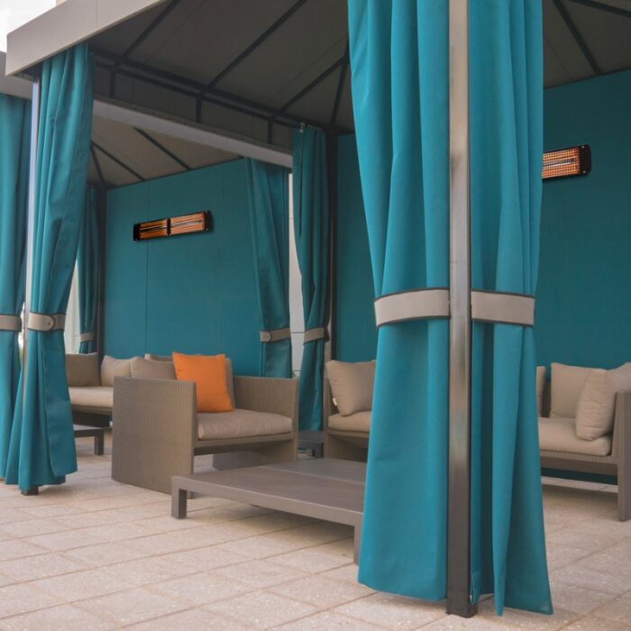 Modern outdoor lounge area with teal curtains, comfortable seating, and a wall-mounted heater, ideal for relaxation and entertaining.