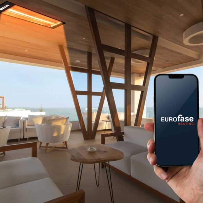 Modern indoor space featuring Eurofase heating system, with a hand holding a smartphone displaying the Eurofase logo, overlooking a scenic view.