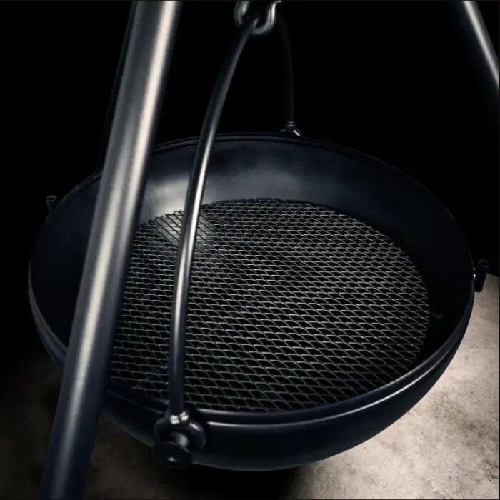 Cast iron grill with a mesh cooking surface, supported by a sturdy hanging frame.