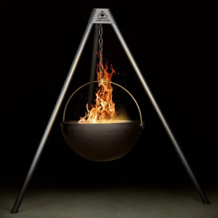 A cauldron suspended from a metal tripod, emitting flames inside, creating a dramatic and warm ambiance against a dark background.