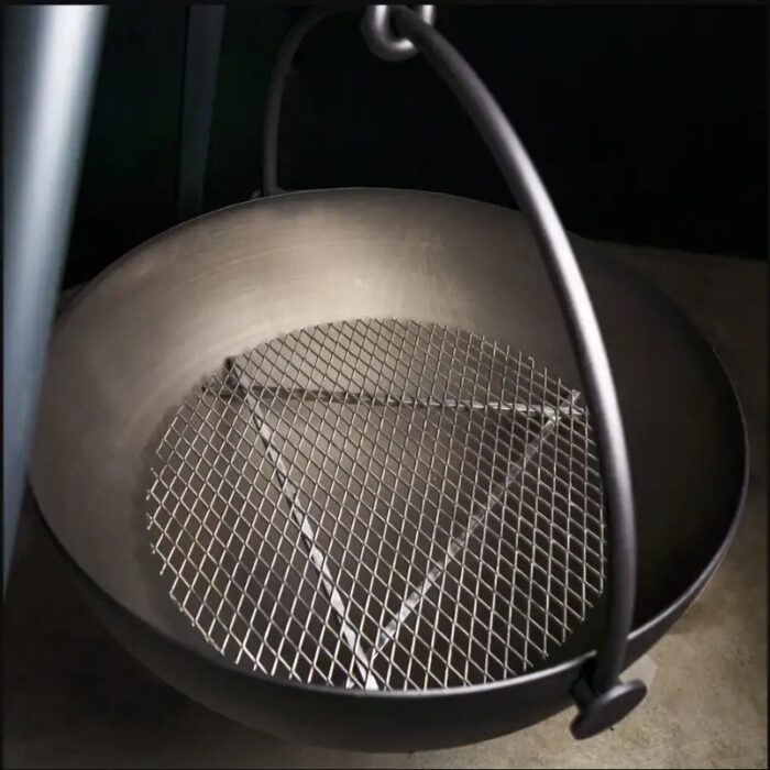 Metal fire pit bowl with a triangular mesh grate inside, designed for outdoor use, featuring a sturdy handle and a sleek finish.