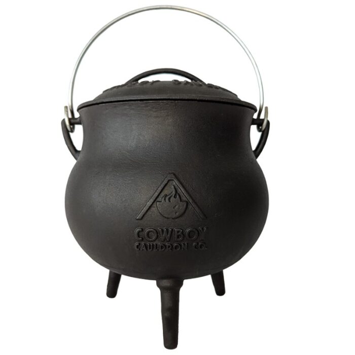 Black cast iron cauldron with a handle and three legs, featuring the logo of Cowboy Cauldron Co.
