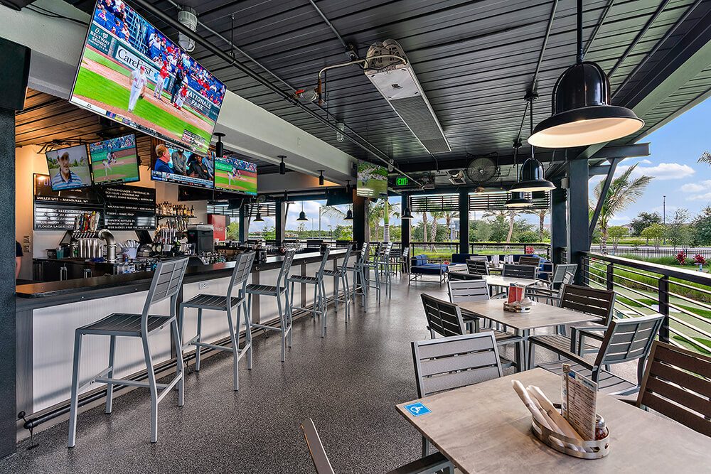 Covered sports bar patio with overhead tube heaters, televisions and bar seating