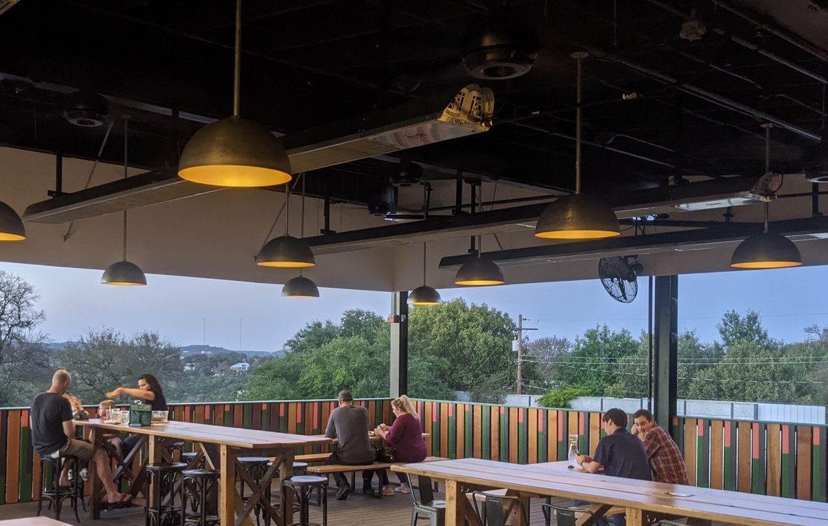 evenTUBE tube heaters mounted on the ceiling of a rooftop bar patio with communal tables