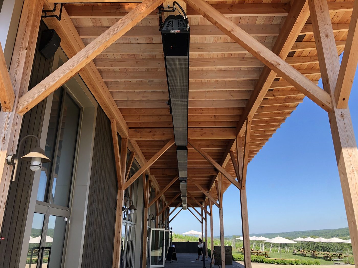 Long evenTUBE tube heater running the length of a timber-framed winery terrace